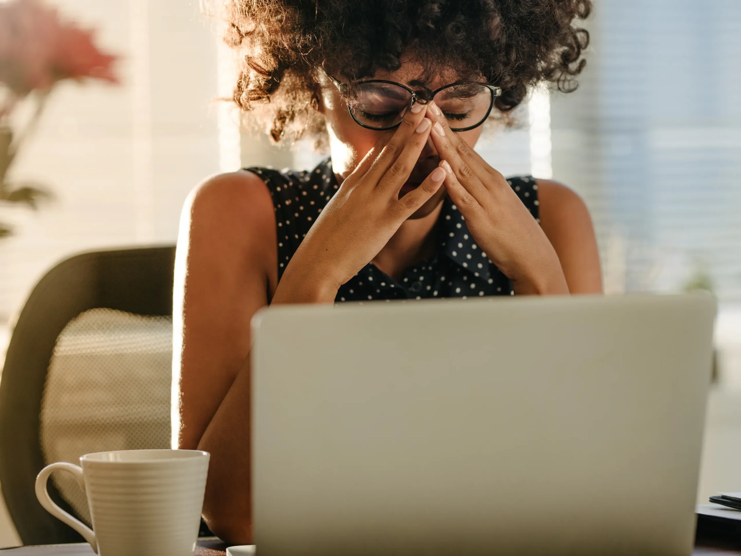 woman rubbing head while looking a her laptop - stressed