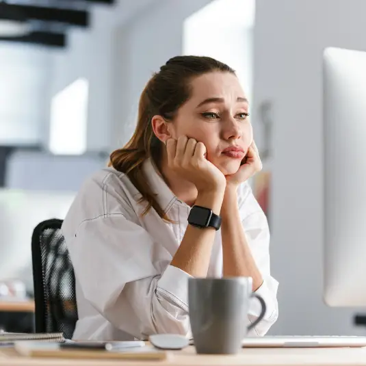 Woman sits at desk with brain fog