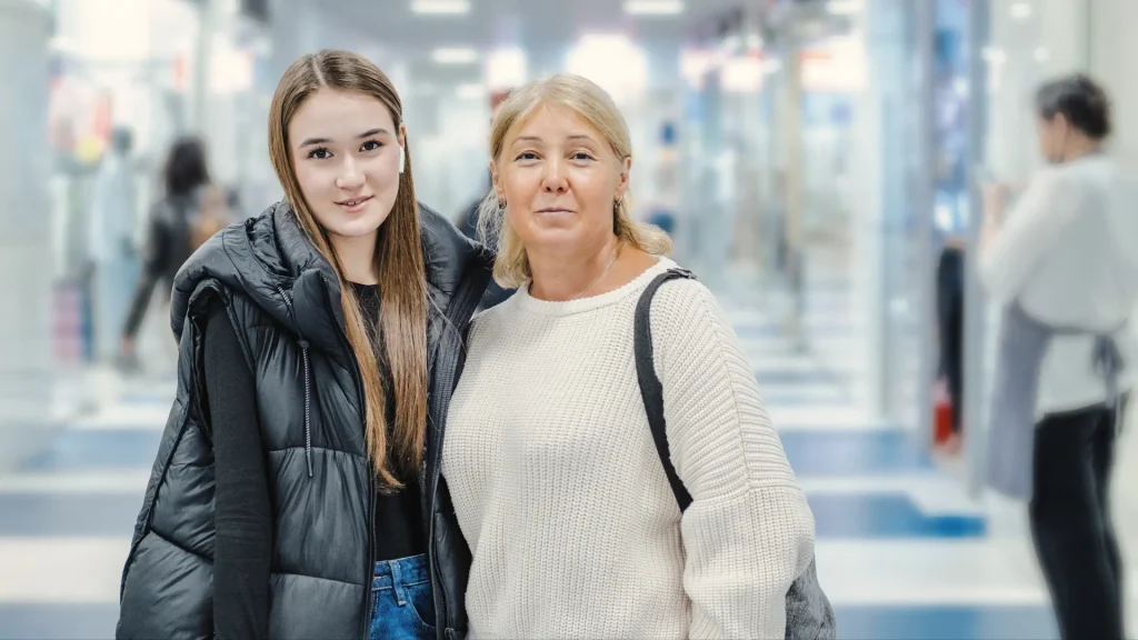 Mom and teenage daughter standing in the mall hallway