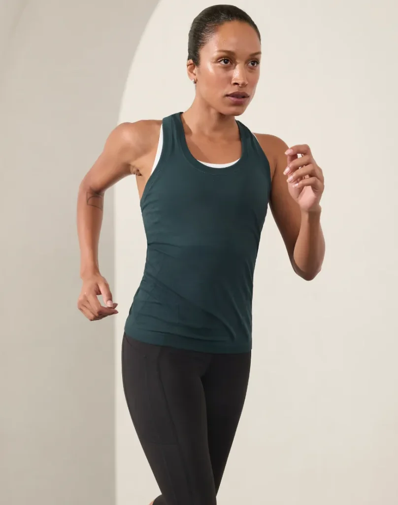 Athleta model wearing a navy blue Momentum Tank
